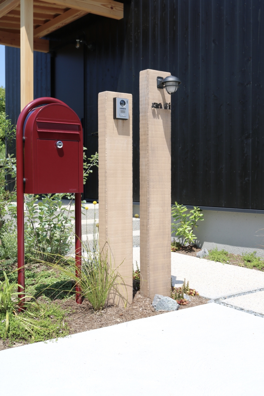総社市、赤いポストと木調門柱のクローズアップ