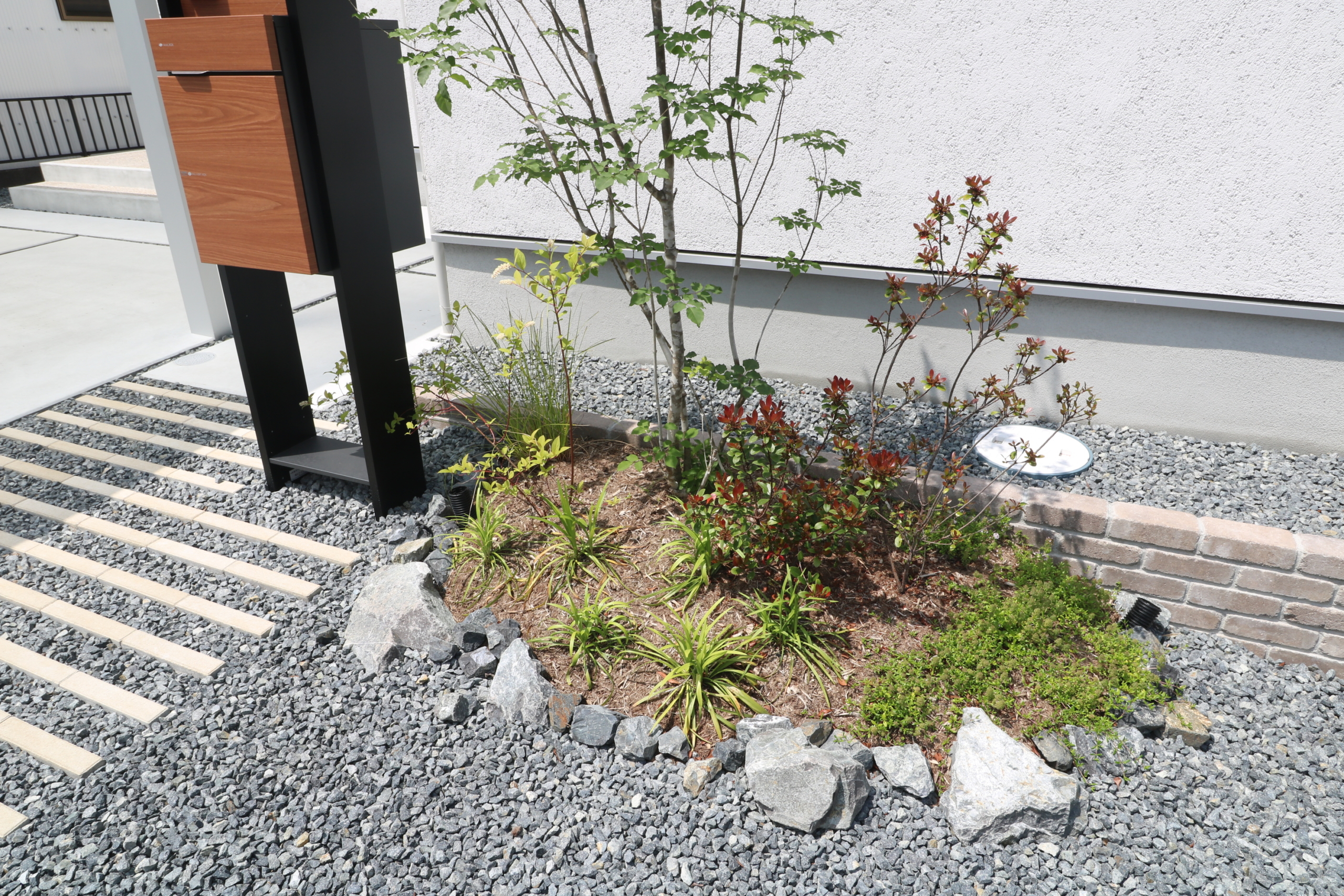 門柱横の植栽 シンボルツリーのアオダモと足元の自然石